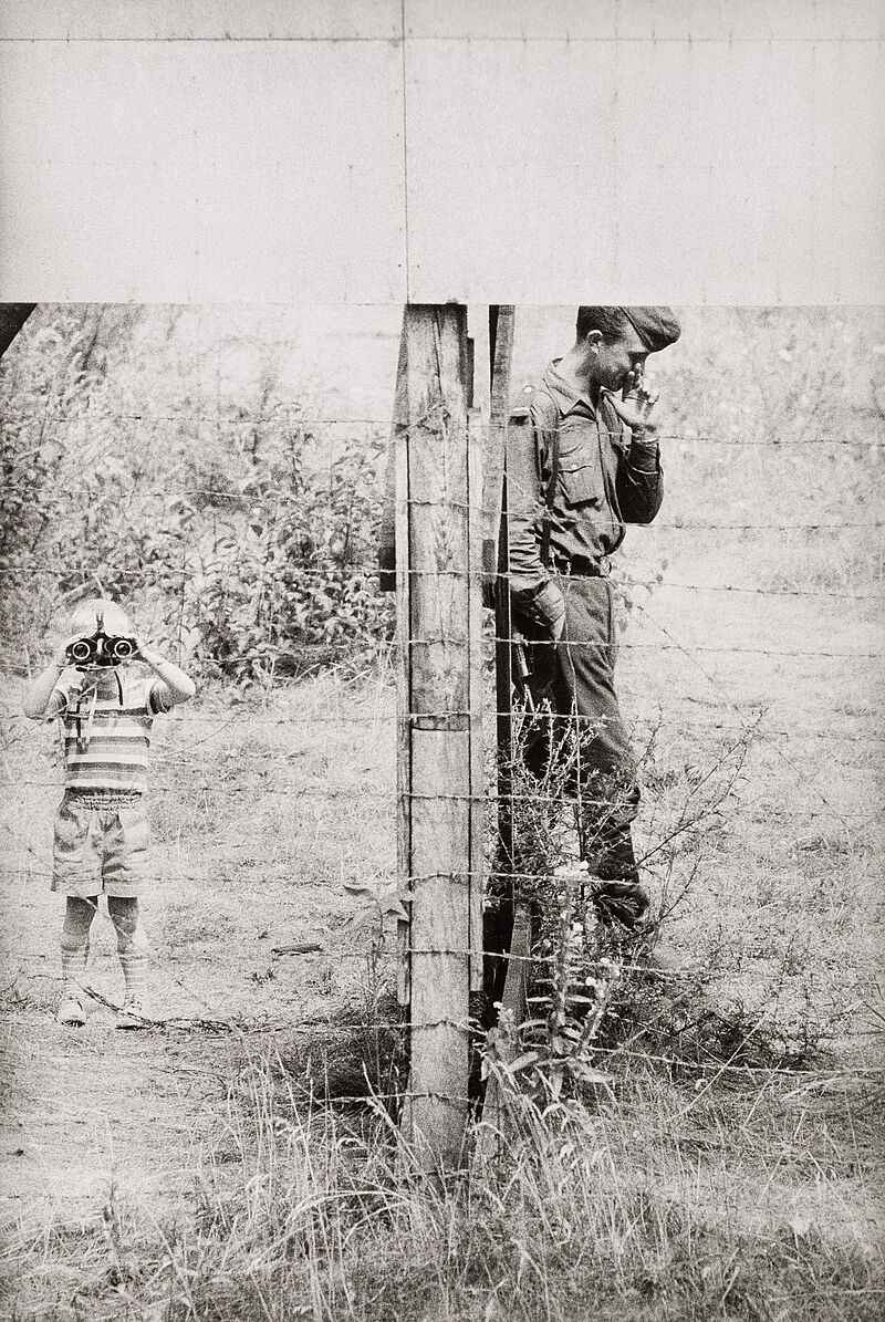 Thomas Hoepker, Ein kleiner Junge schaut durch das Fernglas eines DDR-Grenzsoldaten nach Westen, Berlin, 1963