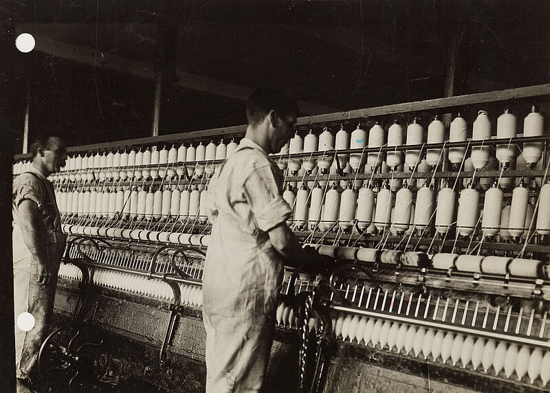 Philipp Kester, Zwei Arbeiter am Spinnapparat – Szene in einer Baumwollspinnerei in Lancashire, ca. 1909