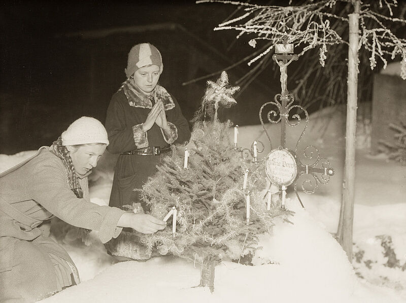 Philipp Kester, Weihnachten – Zwei Kinder vor einem Weihnachtsbaum auf einem Friedhof