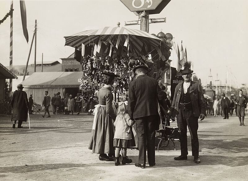 Philipp Kester, Münchner Oktoberfest – Familie mit einem kleinen Mädchen an einem Spielzeugstand, 1935