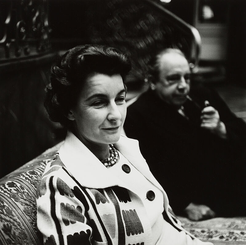 Barbara Niggl Radloff, John B. Priestley und Jacquetta Hawkes im Hotel Vier Jahreszeiten [sitzend auf Sofa, er im Hintergrund verschwommen und Pfeife rauchend], 1960