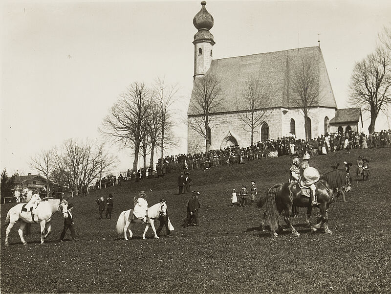 Philipp Kester, Georgiritt in Traunstein – Der Zug erreicht das alte Wallfahrtskirchlein von Ettendorf, 1912